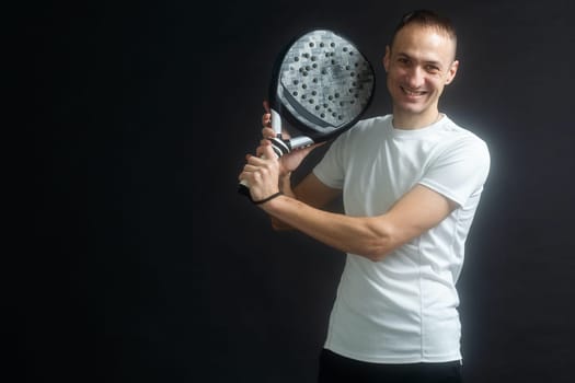 Beautiful man playing paddle tennis, racket in hand concentrated look. Young sporty boy ready for the match. Focused padel athlete ready to receive the ball. Sport, health, youth and leisure concept. High quality photo