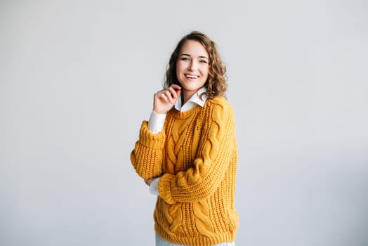 Joyful Young Woman: Smiling, Beautiful, and Charming Model - Positive, Cheerful, and Pretty - Curly-haired Student Laughs, Looks at Camera - Isolated Portrait on White Background - Expressive and Satisfied Expression