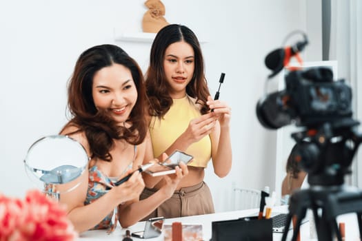 Asian Woman influencer shoot live streaming vlog video review makeup uttermost social media or blog. Happy young girl with cosmetics studio lighting for marketing recording session broadcasting online