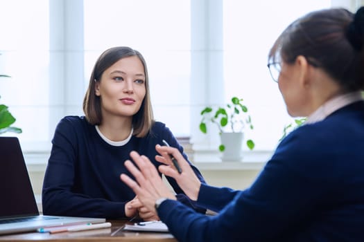 Young woman patient at meeting session with female psychologist therapist social worker counselor psychotherapist. Mental health professional help support treatment psychology psychotherapy counseling