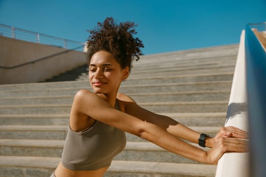 Female athlete in sportswear have a rest after morning jogging outside and looks away