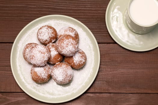 Fat Thursday Carnival or Tlusty Czwartek, Christian tradition. Top View Of Zeppole Or Paczki On Plate With Powdered Sugar, Cup Of Milk On Wooden Table. Doughnut, Delicious Donuts. Horizontal Plane.