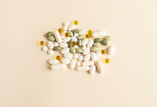 Assorted Pile of Colorful Pills, Green White Yellow, Beige Tablets, Vitamins, Capsules, Medical Supplement on Beige Background. Pharmaceutical concept. Horizontal Plane. High quality photo