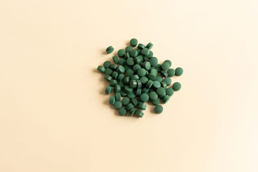 Flat Lay Vitamin, Easy To Swallow Green Pills Of Natural Spirulina On Beige Background. They Are Made Of Blue-green Algae With Strong Antioxidant Effects. Horizontal. High quality photo