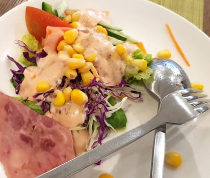 delicious breakfast, ham and fresh summer salad on white plate, on wooden table, view from above, good for your multimedia content background