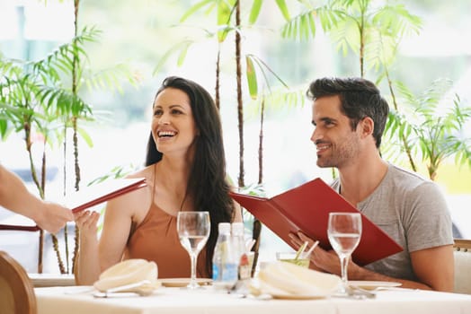 Couple, restaurant and menu with lunch, romance and love for anniversary or celebration. Woman, man and date with luxury, fine dining and smile for relationship on holiday or vacation with meal.