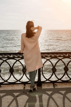 Woman travel sea. Young Happy woman in a long red dress posing on a beach near the sea on background of volcanic rocks, like in Iceland, sharing travel adventure journey