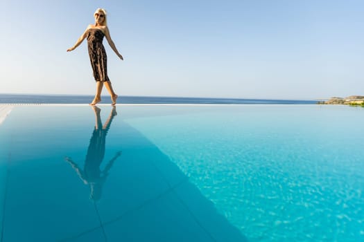woman near the pool. By Swimming Pool On Travel Holidays Vacation. Beauty, Wellness, Lifestyle