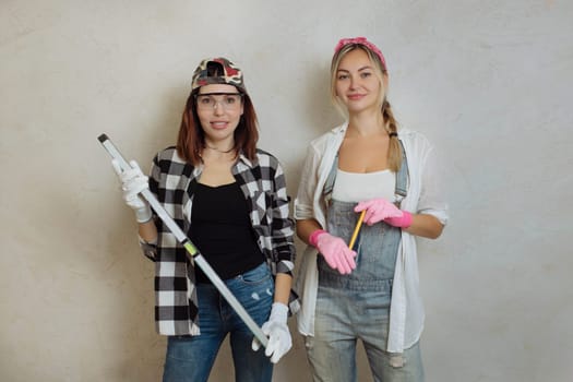Wipes two sexy girls with a construction tool in their hands. Repair with their own hands inside the house.