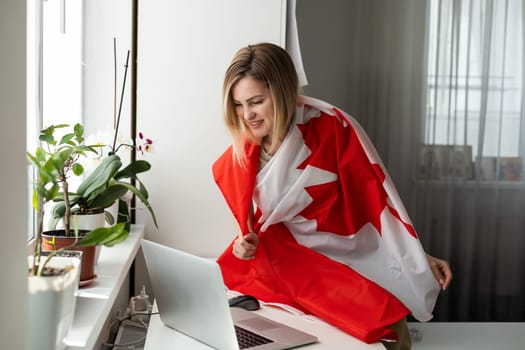 woman hands and flag of Canada on computer, laptop keyboard . High quality photo