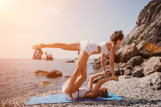 Woman sea yoga. Back view of free calm happy satisfied woman with long hair standing on top rock with yoga position against of sky by the sea. Healthy lifestyle outdoors in nature, fitness concept.