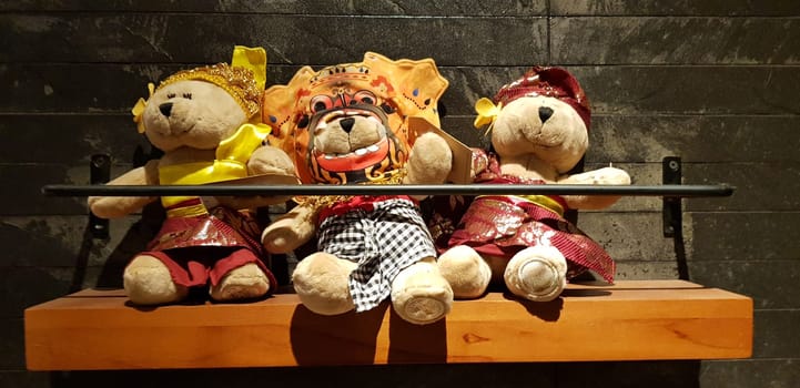 Group of Fluffy Stuffed Bear Toys Wearing various Clothes, teddy bear stuffed animal sitting in the wood bracket