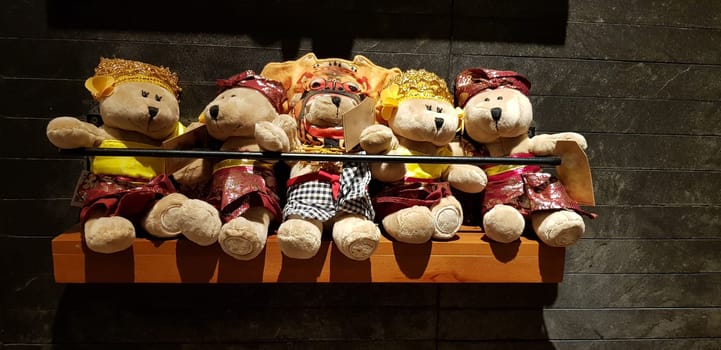 Group of Fluffy Stuffed Bear Toys Wearing various Clothes, teddy bear stuffed animal sitting in the wood bracket