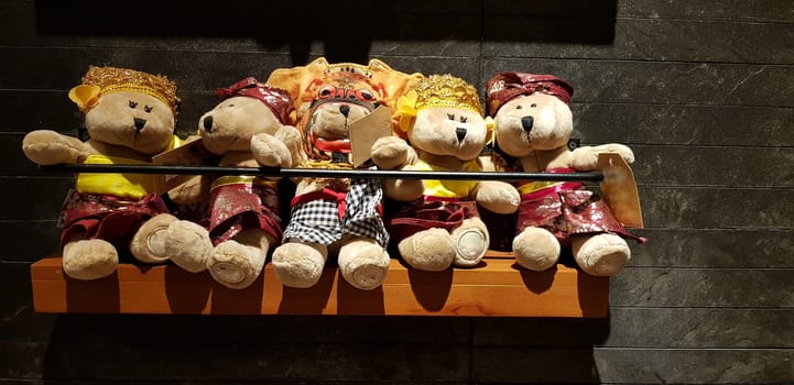 Group of Fluffy Stuffed Bear Toys Wearing various Clothes, teddy bear stuffed animal sitting in the wood bracket