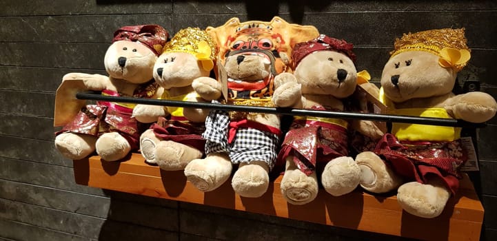 Group of Fluffy Stuffed Bear Toys Wearing various Clothes, teddy bear stuffed animal sitting in the wood bracket