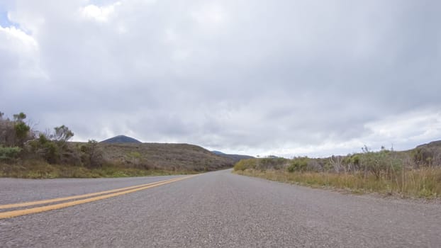 In this serene winter scene, a vehicle carefully makes its way along Los Osos Valley Road and Pecho Valley Road within Montana de Oro State Park.