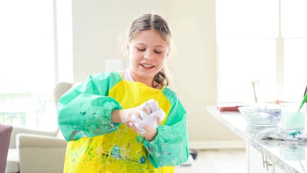 In a modern kitchen, a homeschooled girl is engrossed in creating homemade slime, a fun and educational hands-on project that enhances her creativity and problem-solving skills.