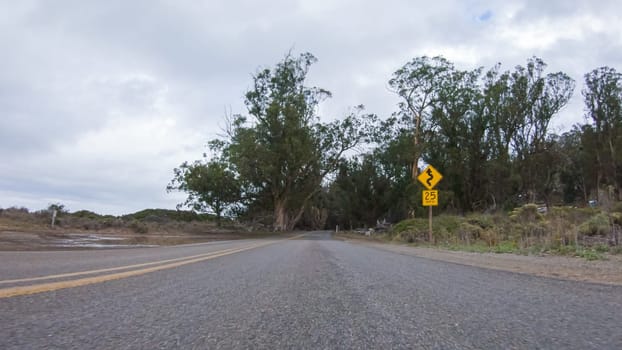 In this serene winter scene, a vehicle carefully makes its way along Los Osos Valley Road and Pecho Valley Road within Montana de Oro State Park.