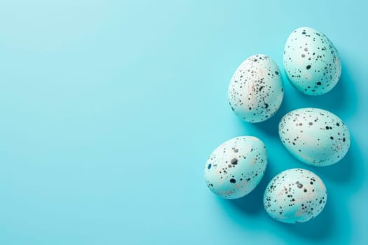 Four speckled eggs arranged on a blue background, with a focus on the delicate patterns and colors of the eggs.