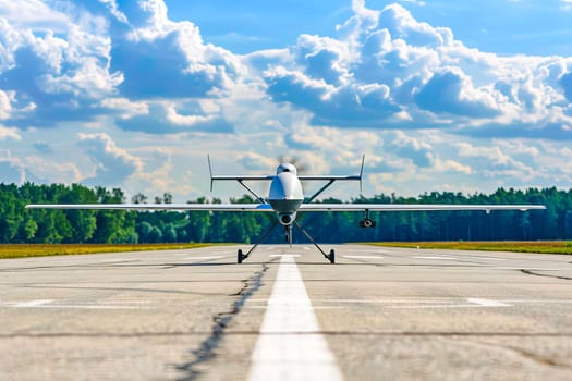 Military unmanned airplane is stationary on the runway, awaiting takeoff or after landing.