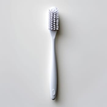 A single white toothbrush against a plain background.
