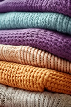 Stack of colorful knitted blankets with textured patterns.