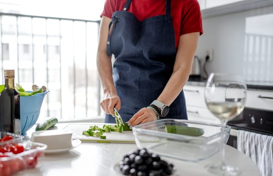 Woman'S Hands Are Slicing Cucumber For Greek Salad With A Glass Of White Wine Nearby