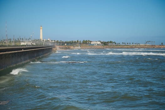 View of sea waves pounding on the headland. lighthouse on the background. Atlantic ocean background. Nature background