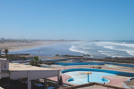 Abandoned swimming pool on the rooftop in Casablanca city, Atlantic beach on the background