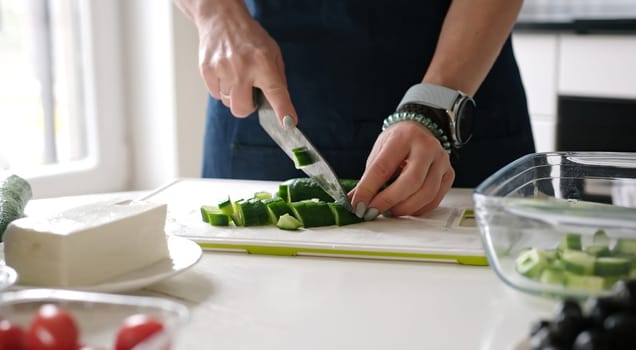 Woman'S Hands Are Slicing Cucumber For Greek Salad With A Glass Of White Wine Nearby