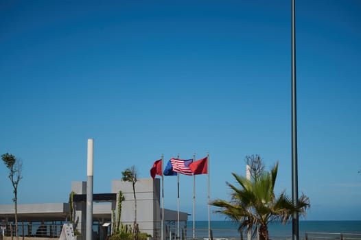 Background with flags of different countries - Moroccan, Spanish, European Union, USA and Great Britain flags over blue sky background