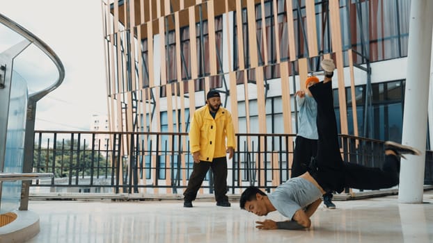 Hip hop team dance break dance while multicultural friend surrounded and clapping hands to cheer or encourage his friend to dance. Active and energetic street dance. Outdoor sport 2024. Endeavor.