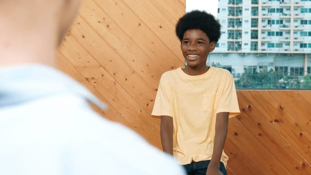 Smiling african boy sitting in circle while listening diverse friend sharing idea in group therapy with trust. Highschool student thinking and learning about mental health problem. Edification.