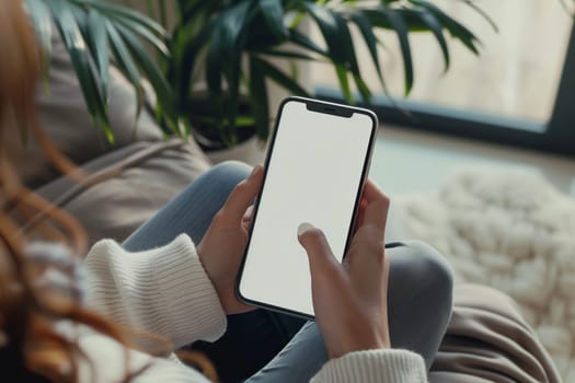 A woman is seated on a couch with a cell phone in her hand, displaying a blank white screen. Her thumb is hovering over the screen, ready to type a message or share an event