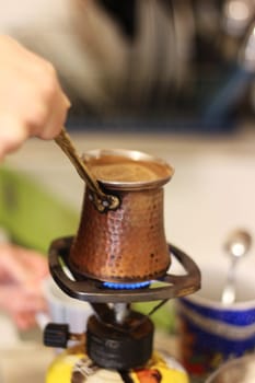 Step into a world of warmth and tradition as Greek coffee brews gently on a small gas burner, reminiscent of the beloved Turkish coffee ritual.