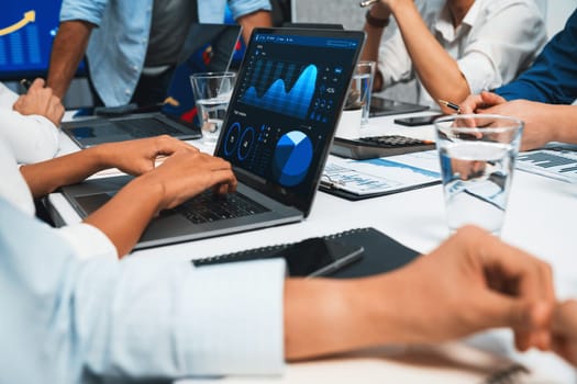 Analyst team utilizing BI Fintech to analyze financial data at table in meeting room. Businesspeople analyzing BI dashboard power for business insight and strategic marketing planning. Prudent