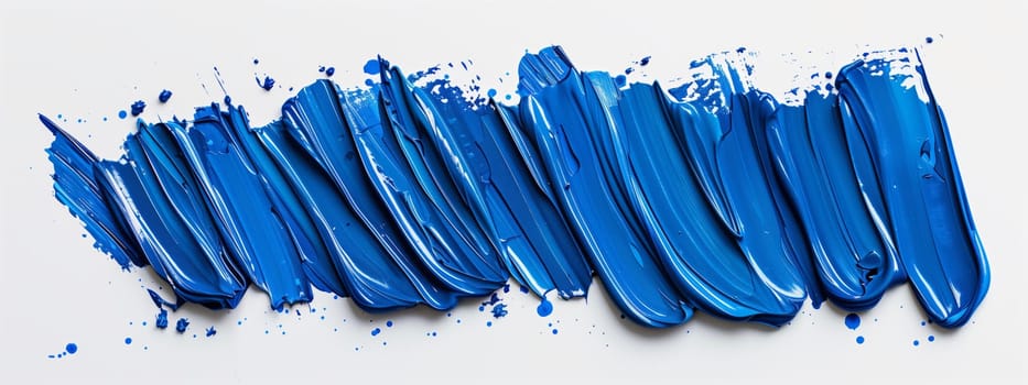 A close up of an electric blue brush stroke on a white plastic surface, resembling a frozen event. The bold stroke forms a sleek rectangle, a fashion accessory in the world of art