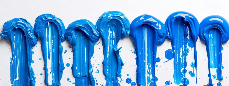 A row of electric blue candy canes painted on a white surface, creating a striking visual arts display. The liquid pattern resembles a fashion accessory