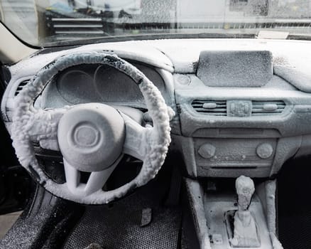 Car interior in a layer of cleaning foam