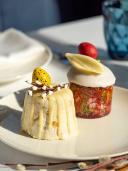 Traditional Easter cottage cheese dessert Paskha decorated with quail eggs and chocolate willow on tabletop background. Modern Orthodox Easter background with two mini cottage curd desserts Paskha