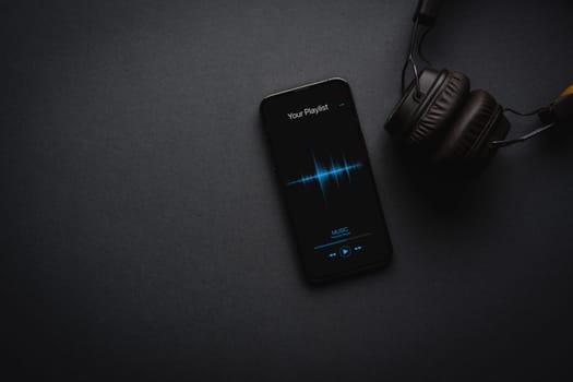 Smartphone with music player app on dark grey background