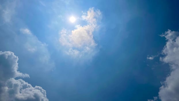 Heavenly white clouds on the blue sky with the sun appeared perfect for multimedia texture or background