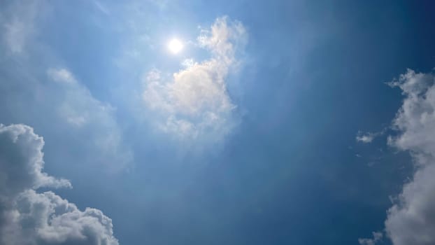 Heavenly white clouds on the blue sky with the sun appeared perfect for multimedia texture or background