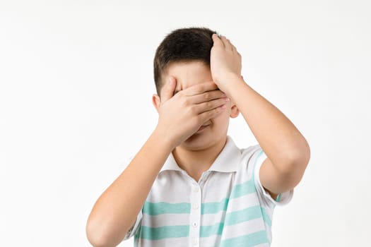 sad little child boy in striped t-shirt on white background. Human emotions and facial expression