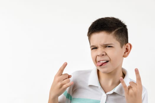 Cute little child boy in striped t-shirt making Rock gesture on white background.