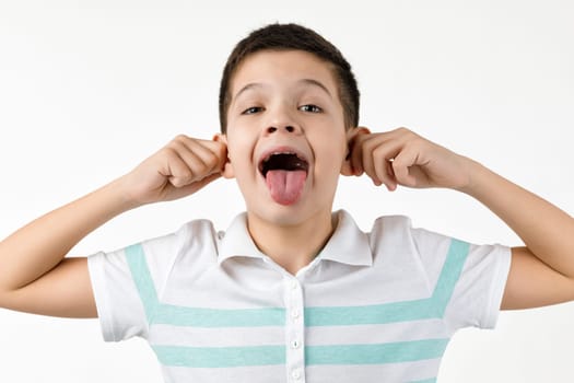 happy funny little child boy in striped t-shirt showing her tongue on white background. facial expression