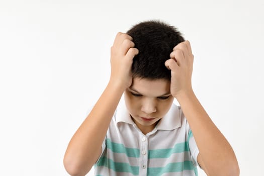 offended sad little child boy in striped t-shirt on white background. Human emotions and facial expression