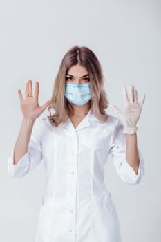 Portrait of woman doctor with face mask doctor shows hands. one gloved hand and the other without
