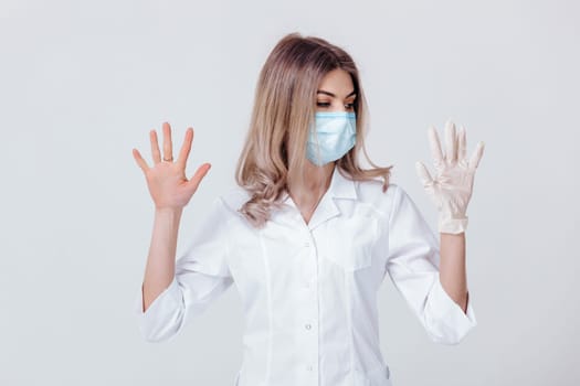 Portrait of woman doctor with face mask doctor shows hands. one gloved hand and the other without