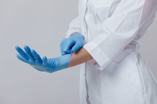 Woman doctor hands wears medical latex blue gloves, close-up